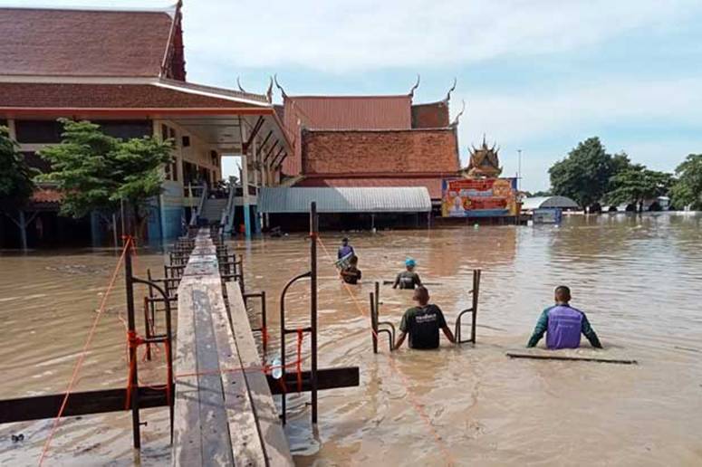 Soldiers build a temporary bridge for monks and worshippers visiting Wat Chula Manee after the temple in Bang Ban district of Ayutthaya province was flooded. (Photo: Sunthong Pongpao)