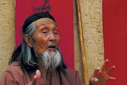Description: [old, grey bearded Chinese man speaks and gestures to camera]
