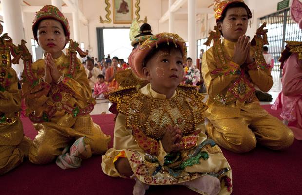 Burmese children dressed traditional clothing attend a Bhuddhist novice ordination ceremony at the Tachilek Shwedagon pagoda  April 1, 2009 in Tachilek, Myanmar. Young boys going into monkhood between the ages of 7 to 14 are ordained as novices to learn the Buddhist doctrines. It is believed that they will gain merit for their family in a country where monks are the most respected order both on a spiritual level and a political one. With such high reverence to the Buddhist religion, the people in Burma consider that the celebrations should be as grand as possible. Tachilek sits on the Thai-Burmese border in Shan State, the  town is a busy trading town for gems full of cheap goods, plus many varieties of copies from China. Many Burmese work in Thailand to make a better wage but live across the border, Burmese also get badly needed medical care in the Thai border town of Mae Sai.