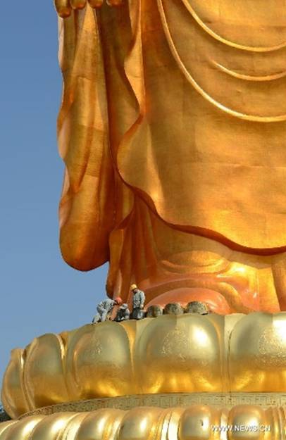 Workers plate gold for the Donglin Buddha statue at the Donglin Temple in Xingzi County of Jiujiang City, east China's Jiangxi Province, March 6, 2013. The bronze statue of Amitabha Buddha, which is 48 meters in height, is believed to be the tallest of its kind in the world. The project, with the total cost of about 1 billion yuan (161 million U.S. dollars), has been basically completed. It was totally funded by private donations. (Xinhua/Song Zhenping)  