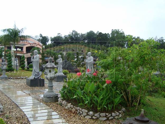 ONE WITH NATURE: Statutes of monks in a garden at the Buddhist Village.
