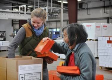 Description: Volunteers load texts into shipping boxes at Ratna Ling's printing press.