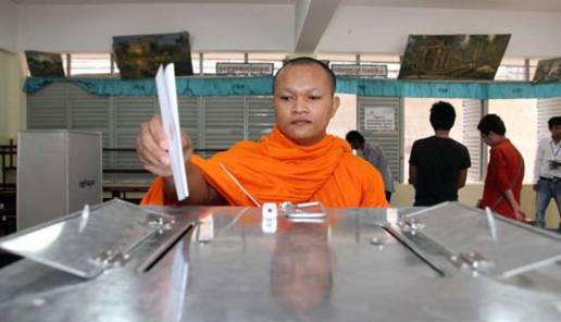 A monk places his vote at a ballot station in Phnom Penh