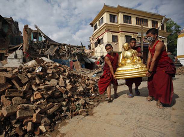 Buddhist monks recover a statue of a Buddhist deity from a monastery at Swayambhunath.