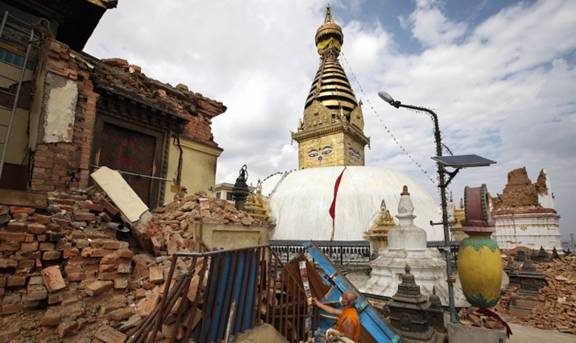 A Buddhist monk salvages religious items from a monastery near the Swayambhunath Stupa. From theguardian.com
