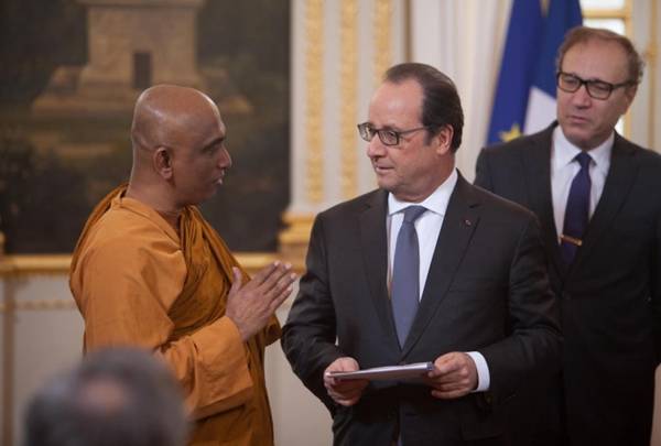 Venerable Rathana Thera in discussion with President Hollande. From Sean Hawkey, World Council of Churches