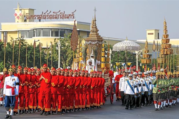 Final journey: Officials marching with the royal carriage containing the remains of the Supreme Patriarch during his cremation ceremony in Bangkok. — Reuters