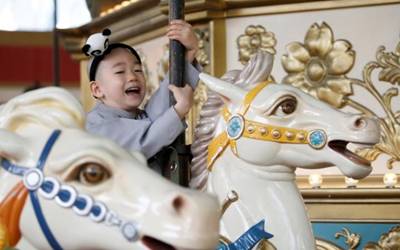 A boy, who is experiencing the lives of Buddhist monks by staying in a temple for two weeks as novice monk, enjoys a ride at the Everland amusement park in Yongin, South Korea, May 9, 2016. 