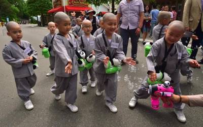 Young South Korean novice monks play with bubbles as they visit an amusement and animal park during their training program entitled 'Children Becoming Buddhist Monks' in Yongin, south of Seoul, on May 9, 2016. A special temple-stay program for children to learn about Buddhism, including shaving their heads and wearing monk's robes, continues for two weeks ahead of celebrations for Buddha's birthday on May 14. / 