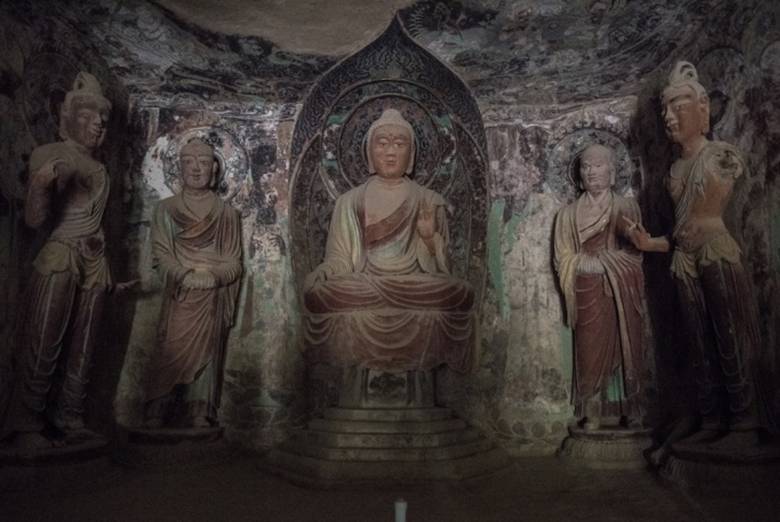 In a Mogao cave, a Buddha statue surrounded by disciples dating from the Tang dynasty (618–907). Photo by Gilles Sabrié. From washingtonpost.com