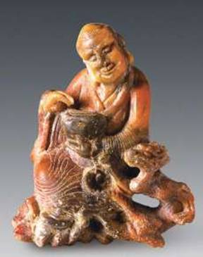An 8.5 centimeter statue of an <i>arhat</i> bearing an alms bowl and standing beside a dragon, carved from agalmatolite. From livescience.com