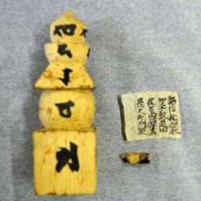 One of the <i>gorinto</i> with Sanskrit written on each section and the paper that was stored inside it. From mainichi.jp