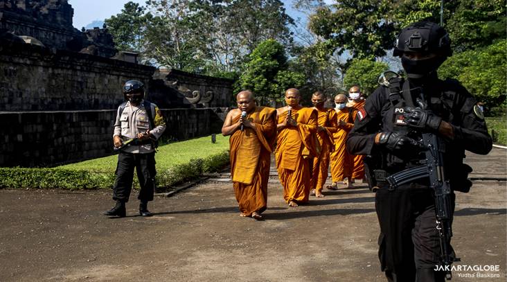 Indonesian police personnels escort Buddhist monks, followed by devotees, participate in a pradakshina ritual during Vesak celebration at the Borobudur Temple in Central Java, on May 26, 2021. (JG Photo/Yudha Baskoro)