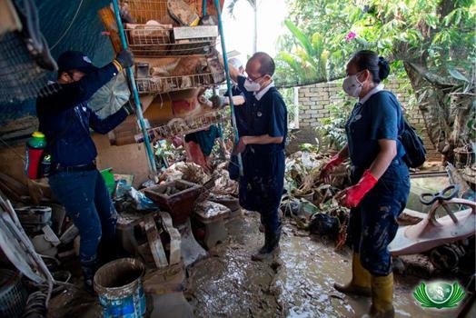 Filepic of volunteers clearing debris from flood-hit houses.